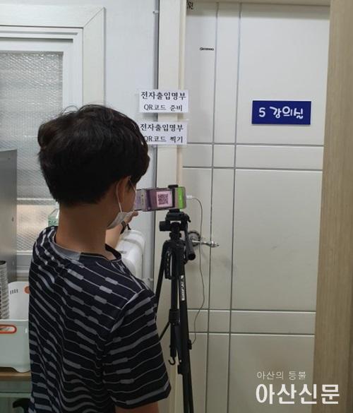 QR코드를 생성하여 학원에 입장하고 있는 학생 사진.jpg